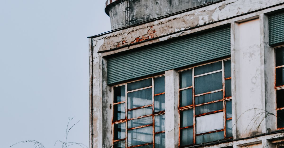 An Old Rusty Building Under White Sky · Free Stock Photo