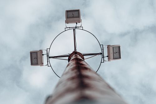 Free Dramatic low angle shot of a high mast lighting pole against an overcast sky. Stock Photo