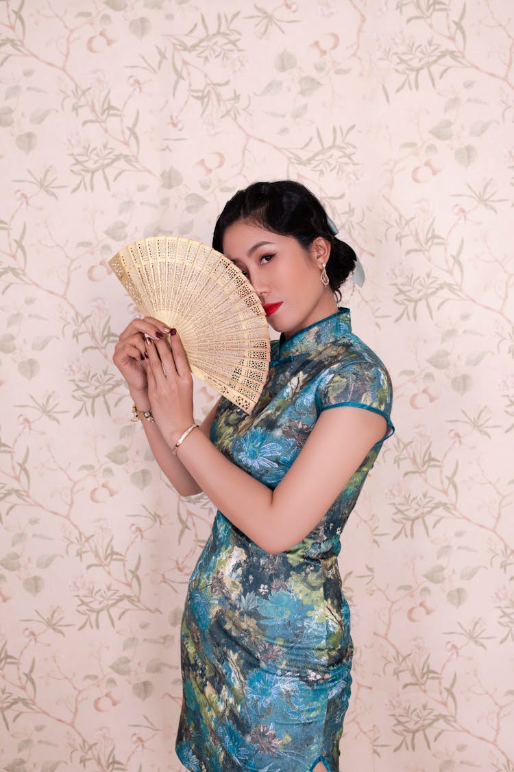 Woman In Cheongsam Holding A Hand Fan