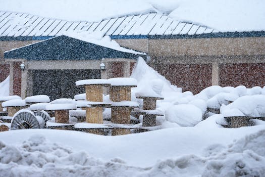 Outdoor scene of snow-covered wooden spools during a heavy winter snowstorm.
