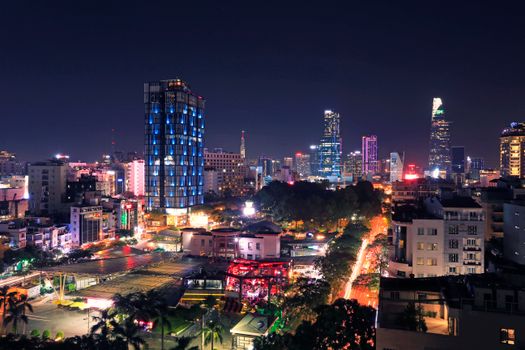Illuminated skyline of Ho Chi Minh City at night showcasing vibrant skyscrapers and bustling streets.
