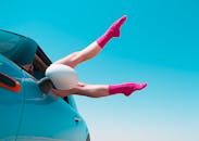 车窗外，一个穿着粉色袜子的女人把腿伸了出来，映衬着鲜艳的蓝天