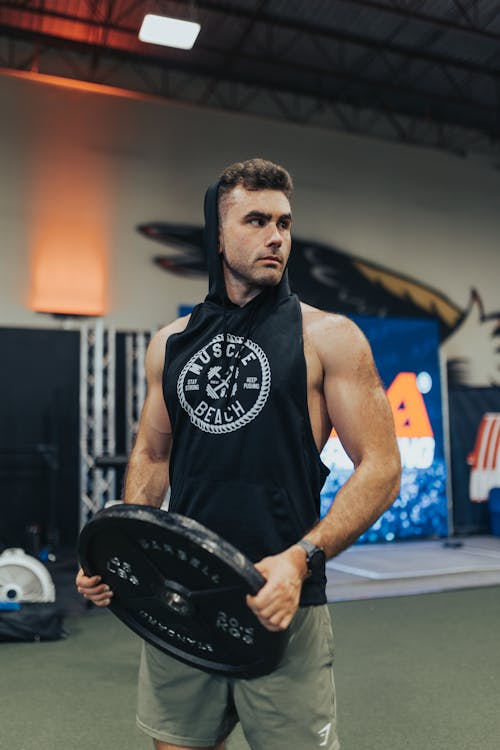 Man Holding Weight Plate in Gym