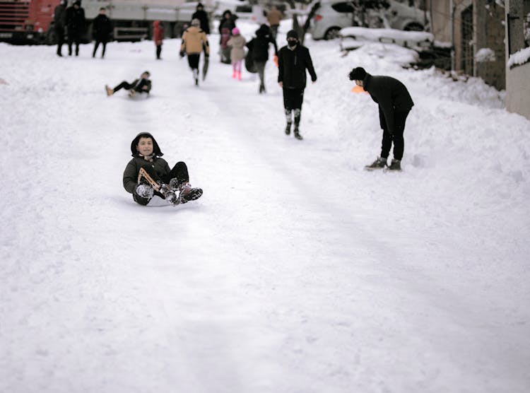 A Boy Sledding Down The Hill