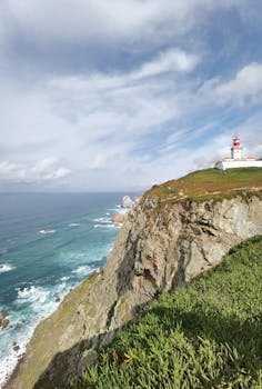 Breathtaking cliffside view of Cabo da Roca lighthouse overlooking the Atlantic Ocean in Portugal.