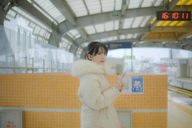 Woman In White Jacket Holding A Phone