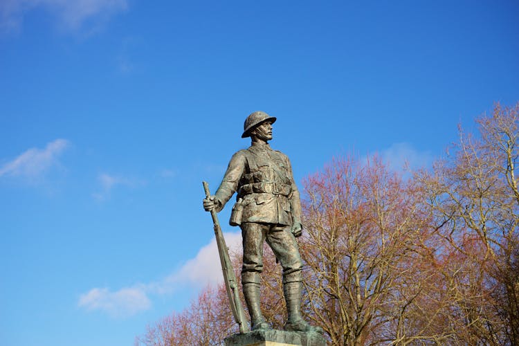 A Concrete Statue Of A Man Holding A Winchester