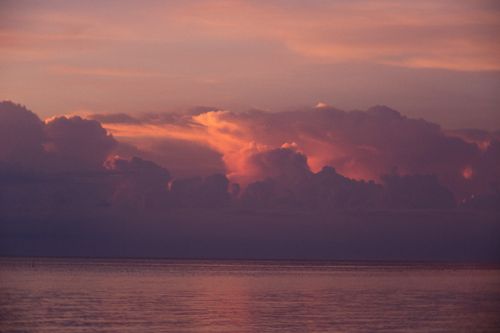 Free Peaceful ocean scene during twilight with stunning clouds capturing dramatic colors. Stock Photo