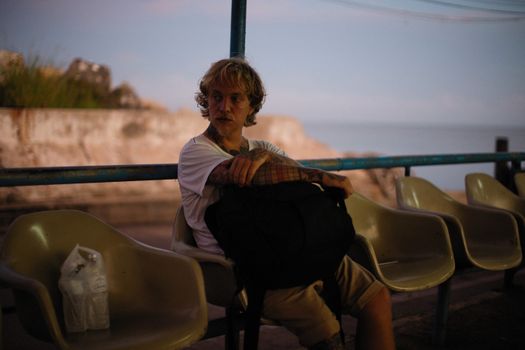 A Man in White Shirt Sitting on a Chair
