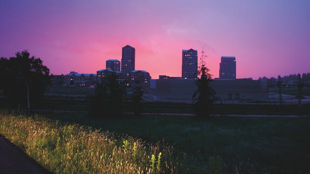 充满活力的紫色日落天空下，迷人的城市景观与建筑物轮廓相映成趣