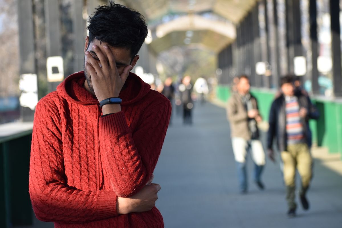 Person standing alone looking troubled and isolated