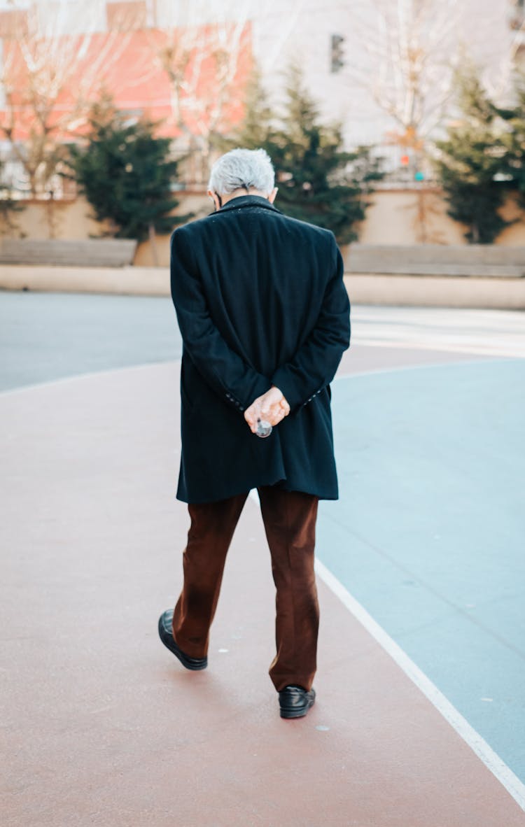 Rear View Of Senior Man Walking In Street