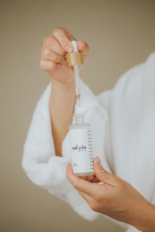 Free Close-up of a person holding a skincare serum bottle with a dropper, ideal for beauty and wellness themes. Stock Photo