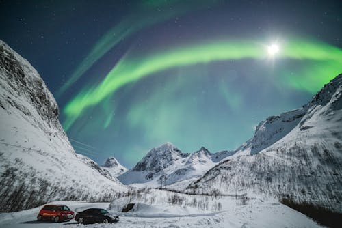 Free Aurora Borealis and Sun Visible in Sky of Northern Norway Stock Photo