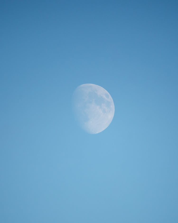 Third Quarter Moon Visible By Day On Blue Clear Sky