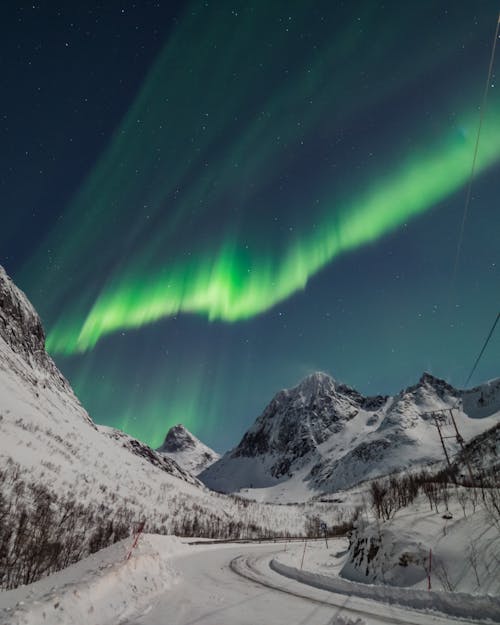 Free Mountain Landscape with Aurora Borealis Shining in Evening Sky Stock Photo