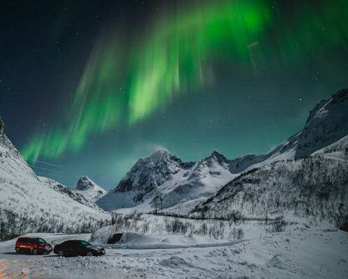 Free Breathtaking Illumination of Aurora Borealis in Mountains of Northern Norway Stock Photo