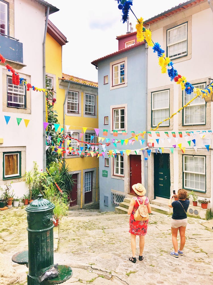 Women Taking Pictures Of Colorful Buildings