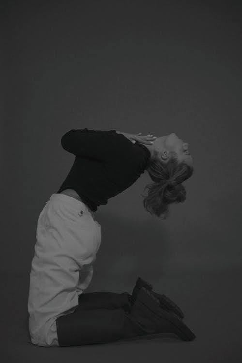 Grayscale Photo of Woman Bending Backwards