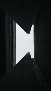 Dramatic low-angle view of concrete structures with minimalistic sky.