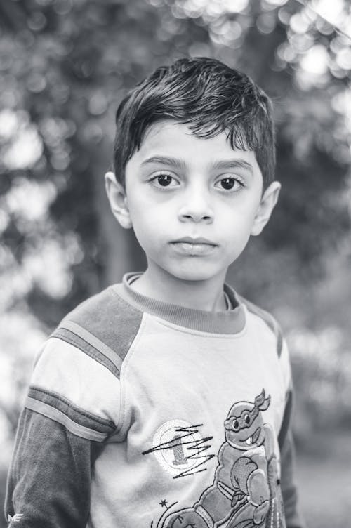 Foto En Escala De Grises De Un Niño Con Camiseta De Manga Larga