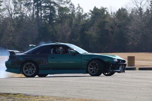 Free Green sports car expertly drifts on a racetrack, showcasing speed and control. Stock Photo