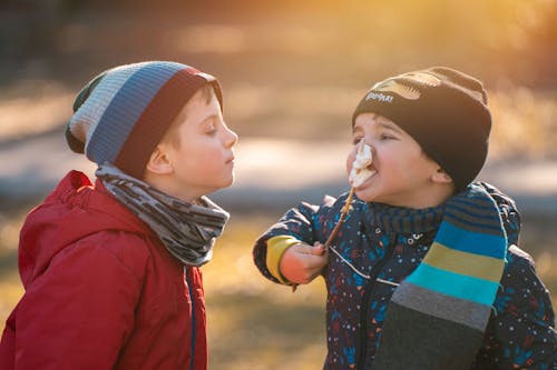 Free Boy in Red Jacket Looking at a Boy Eating  Stock Photo
