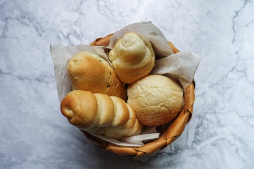 Free Four Brown Breads in Brown Wicker Basket Stock Photo