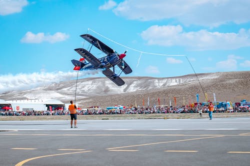 People Watching a Vintage Airplane during an Airshow 