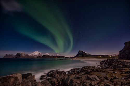 Free Breathtaking view of aurora borealis illuminating the rocky coastline in Nordland, Norway. Stock Photo