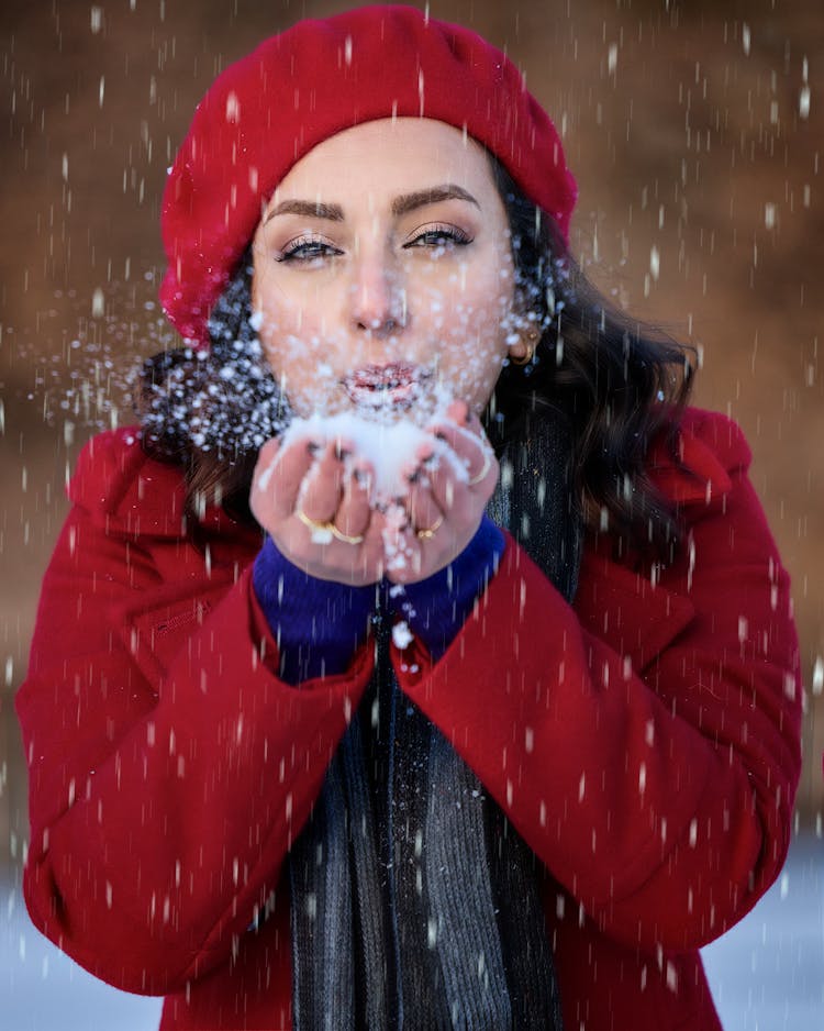 Woman In Red Coat Blowing Snow