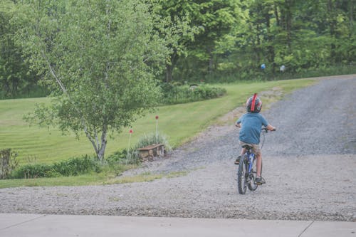 Boy Wearing Blue T-shirt and Beige Shorts Outfit Riding on Black Bicycle at Daytime