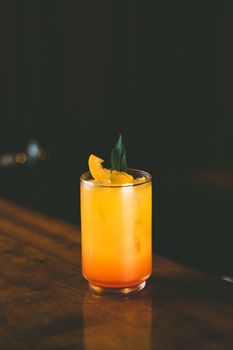 Chilled orange cocktail with mint garnish, perfect for summer relaxation.