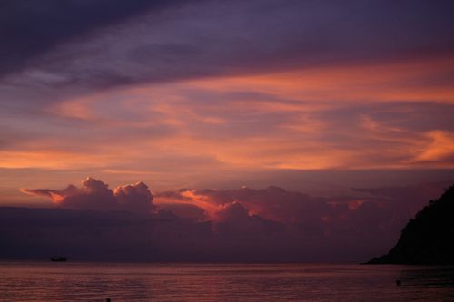Free Breathtaking view of a vibrant sunset over a calm sea with cloudy skies. Stock Photo