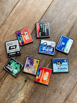 A collection of various flash memory cards arranged on a wooden surface.