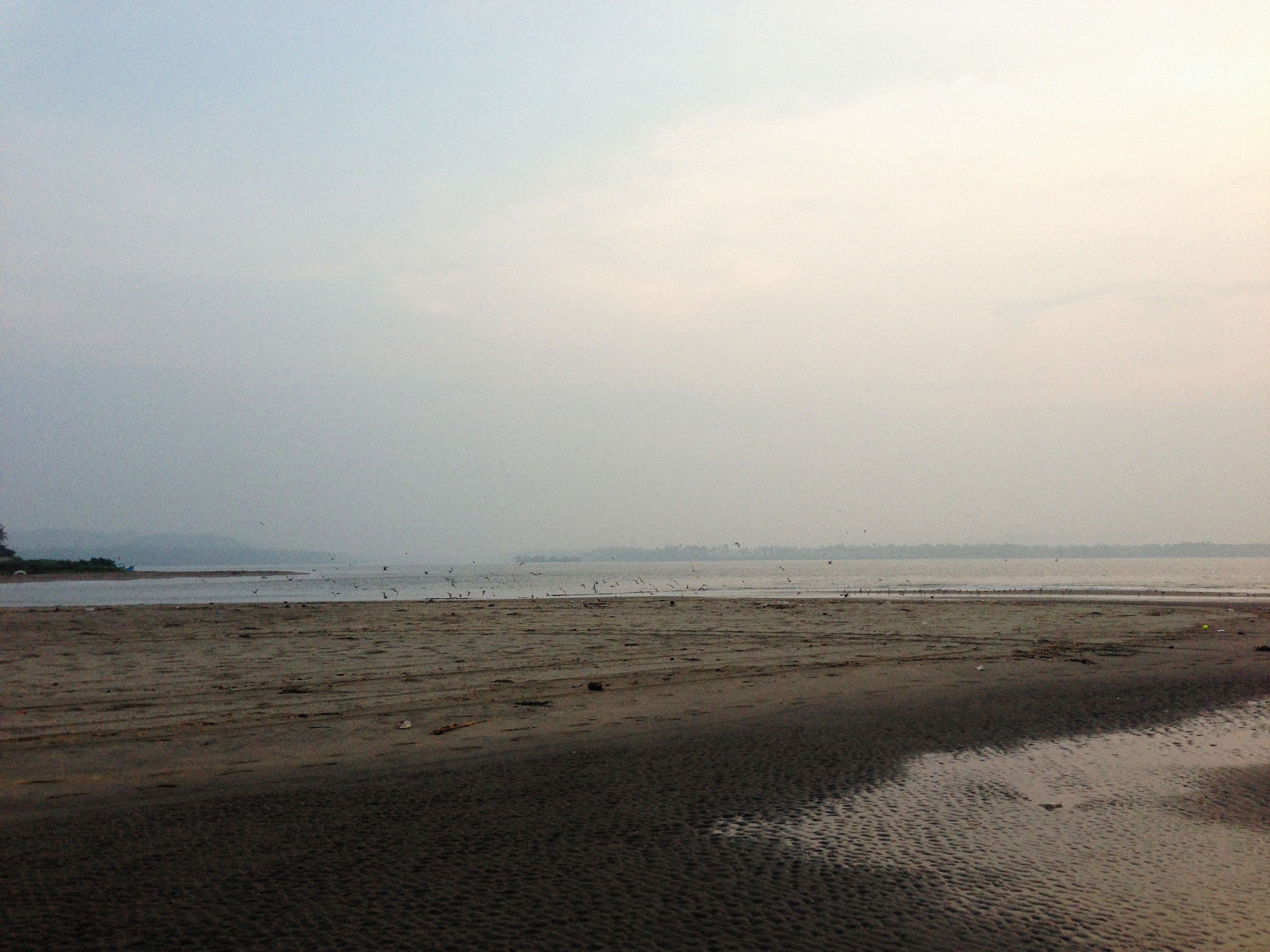 Kolaba Fort standing offshore at low tide from the sand at Alibaug beach