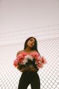 Woman with Flowers by Fence