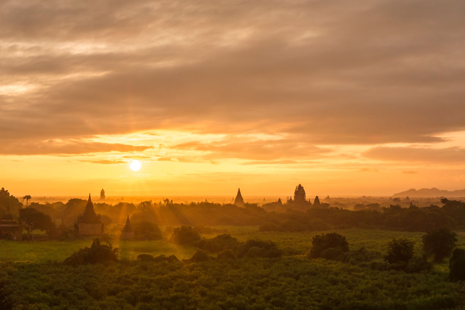 Hot air balloons drifting over ancient Bagan temples at sunrise in Myanmar