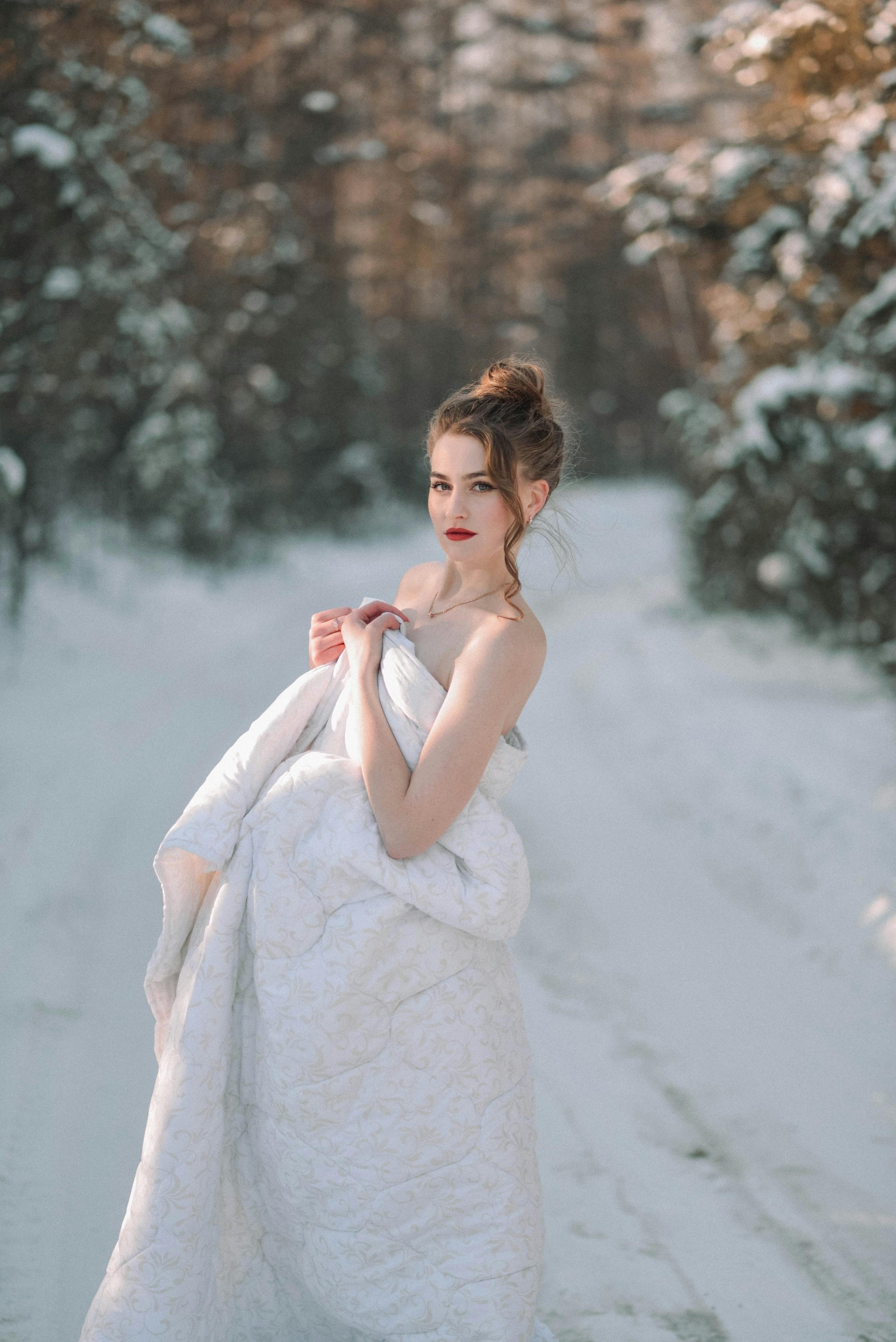 woman covering herself with duvet outside in winter