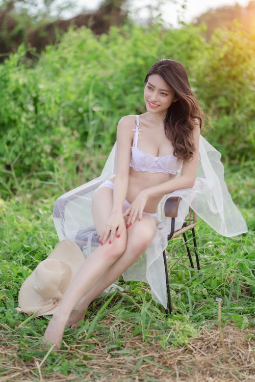 A Woman in White Lingerie Sitting on the Chair