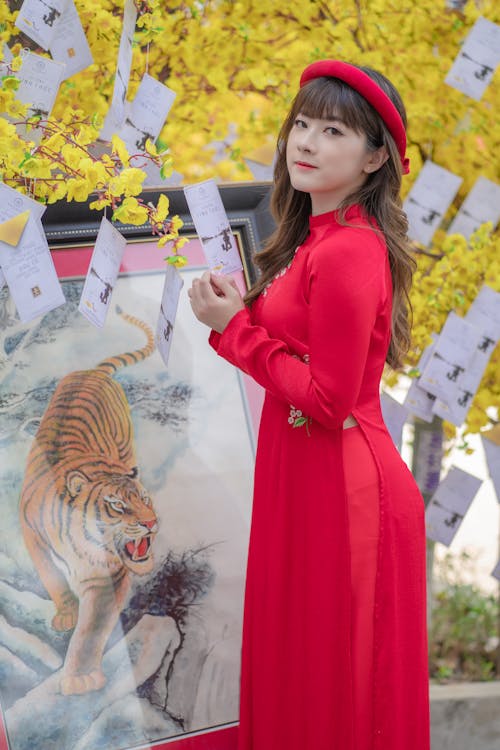 Photo of a Woman in a Red Dress Holding a Letter