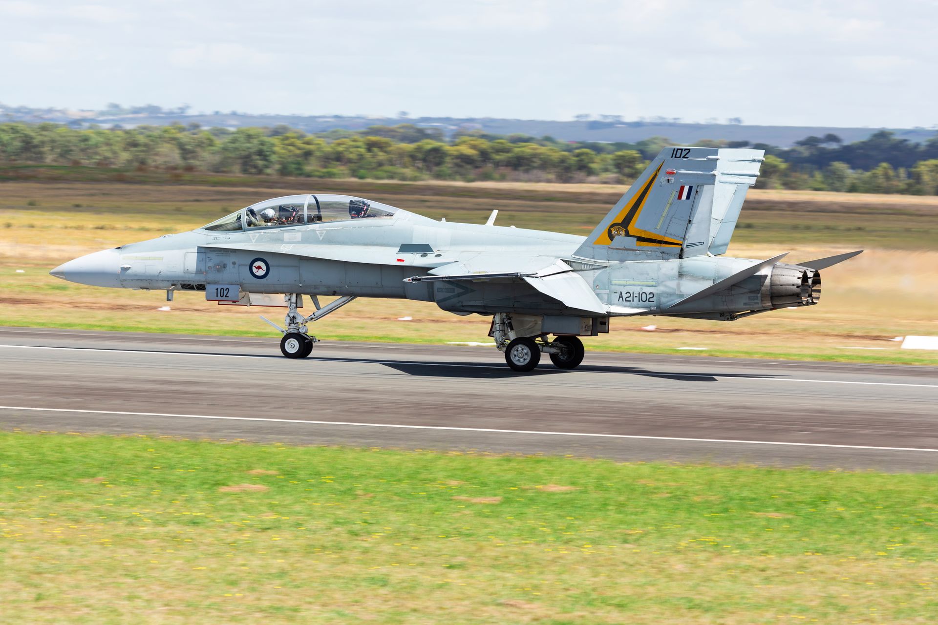 Royal Australian Air Force fighter jet taking off on runway in Lara, Australia on a clear day.