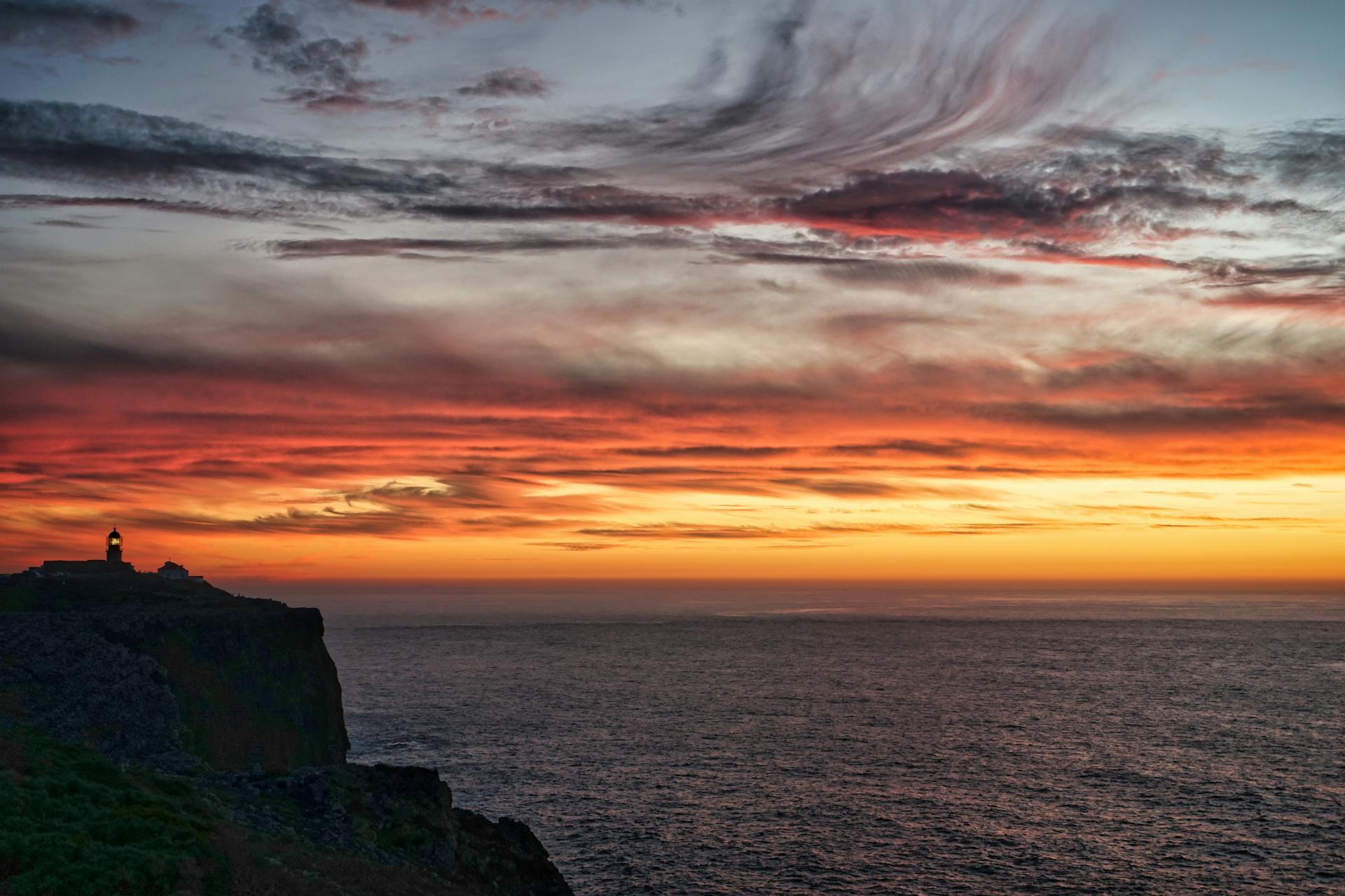Stunning sunset scene at Cape St. Vincent, Sagres, Portugal, with vibrant sky and ocean view.