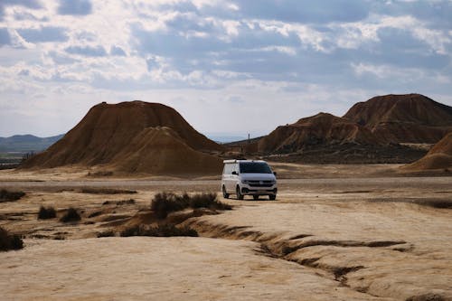 A White Car Near the Mountain Under the White Clouds and Blue Sky