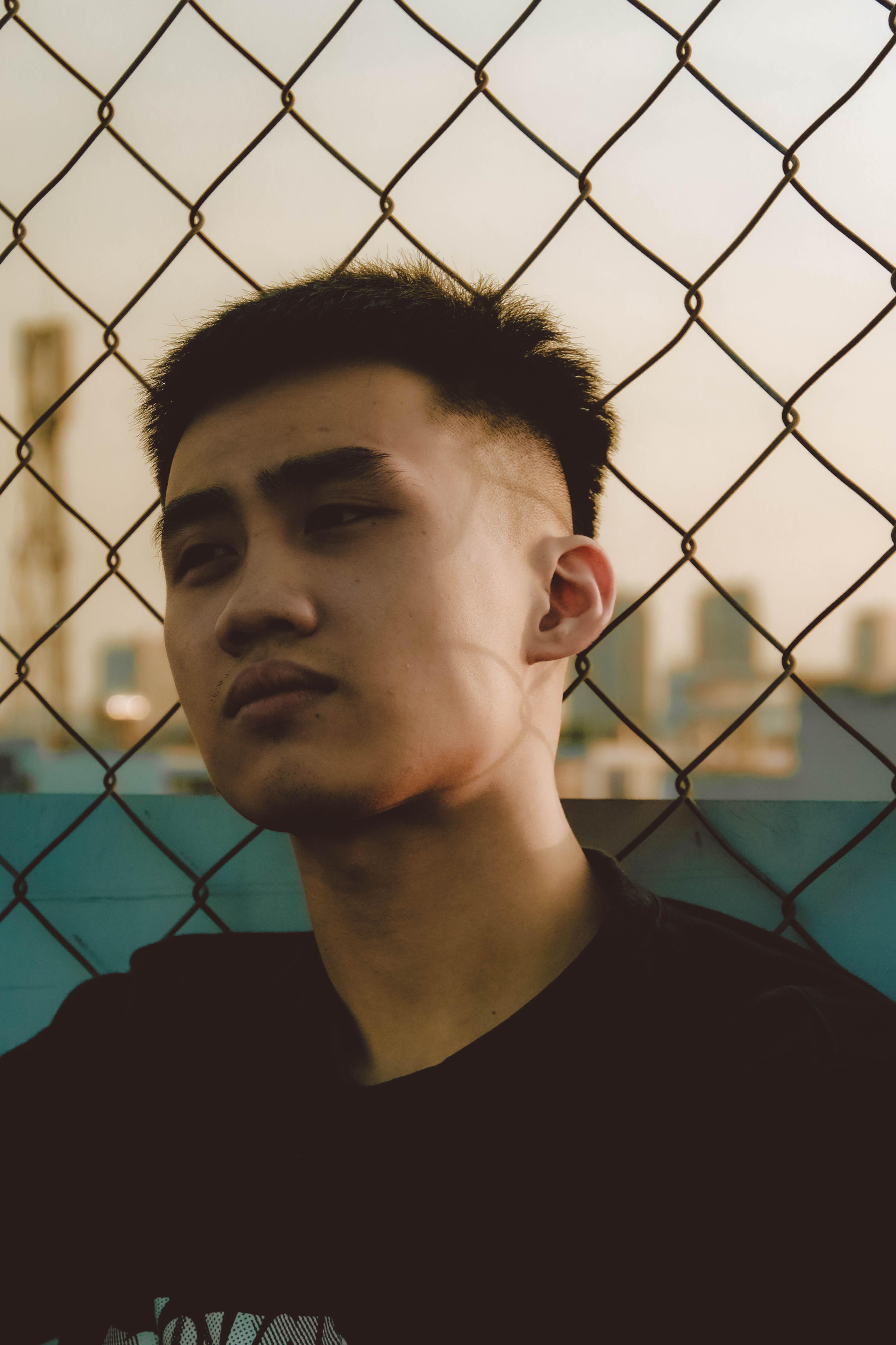 Man in Black Shirt Leaning on Metal Fence · Free Stock Photo