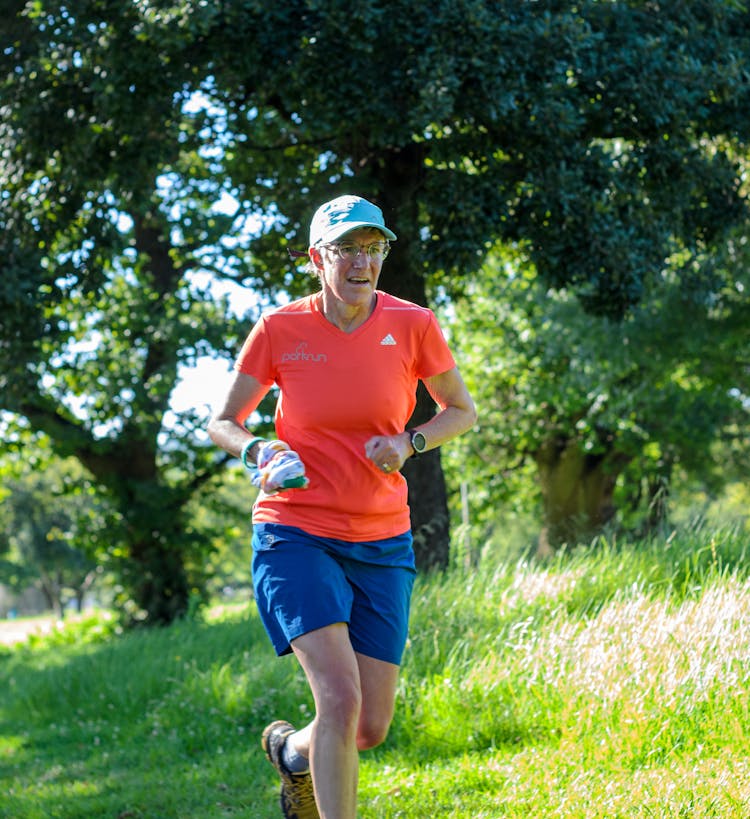 A Woman In Orange Shirt Running