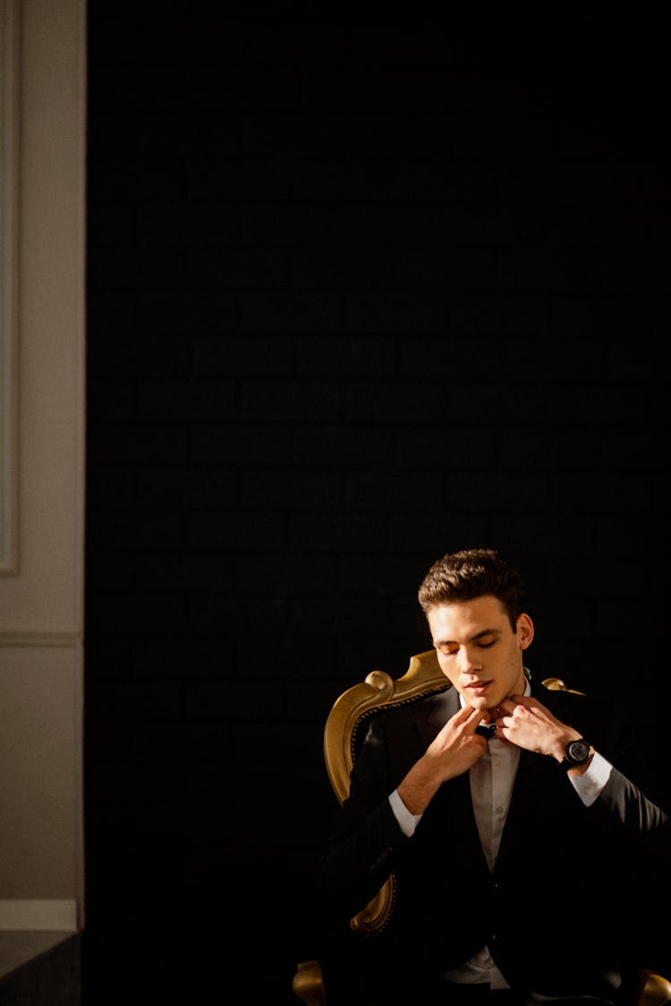 Groom Putting On Wedding Suit