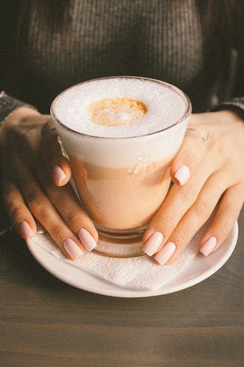 Hands Holding Glass of Latte