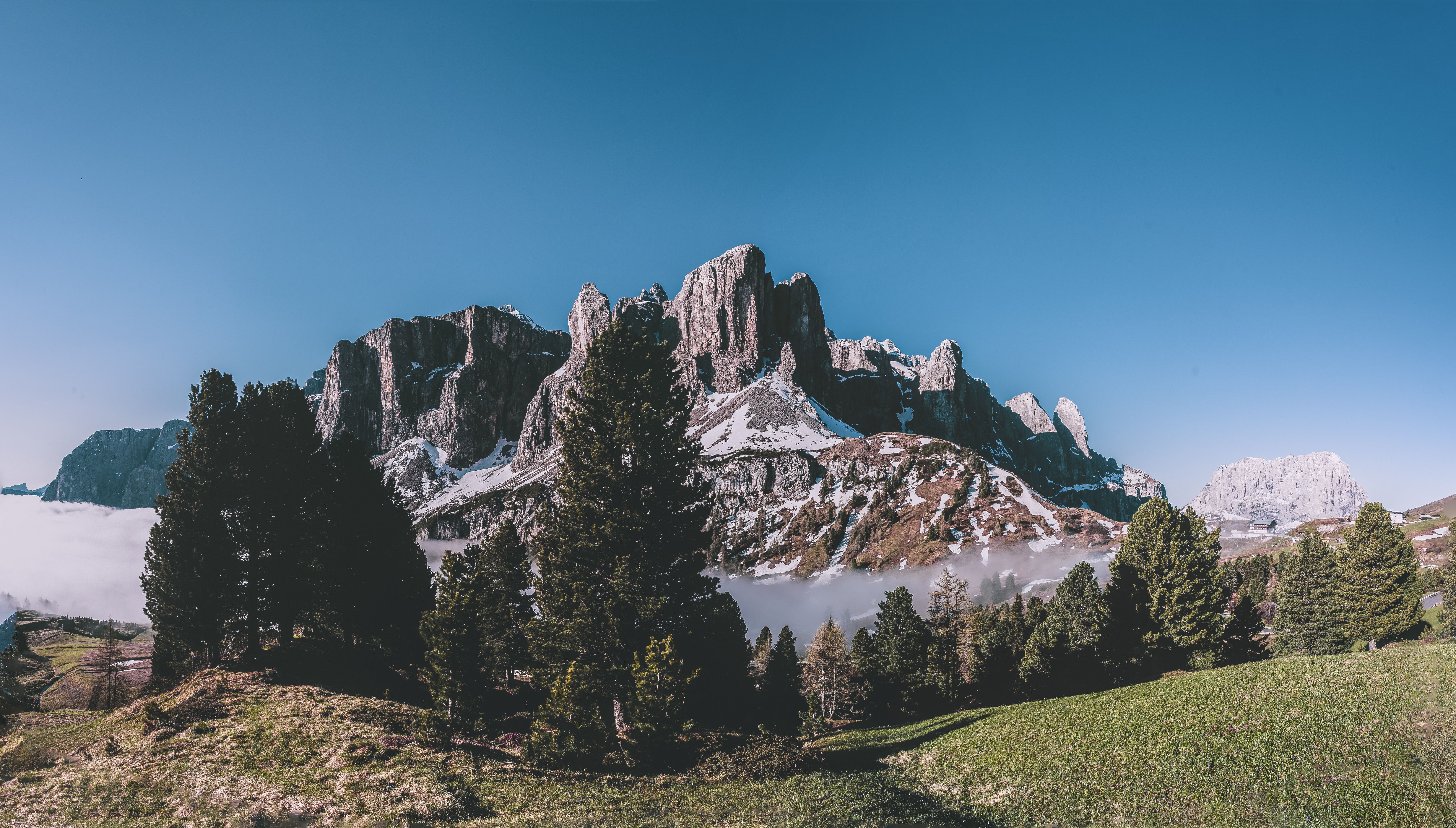 Majestic view of the Dolomites in Selva di Val Gardena, Italy, with clear skies and lush greenery. Majestic view of the Dolomites in Selva di Val Gardena, Italy, with clear skies and lush greenery.
