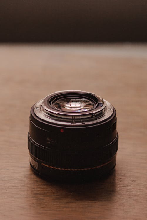 A Camera Lens on a Wooden Surface 